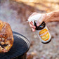 Meat Sweats Bird Bath BBQ spritz being sprayed beside a smoked turkey