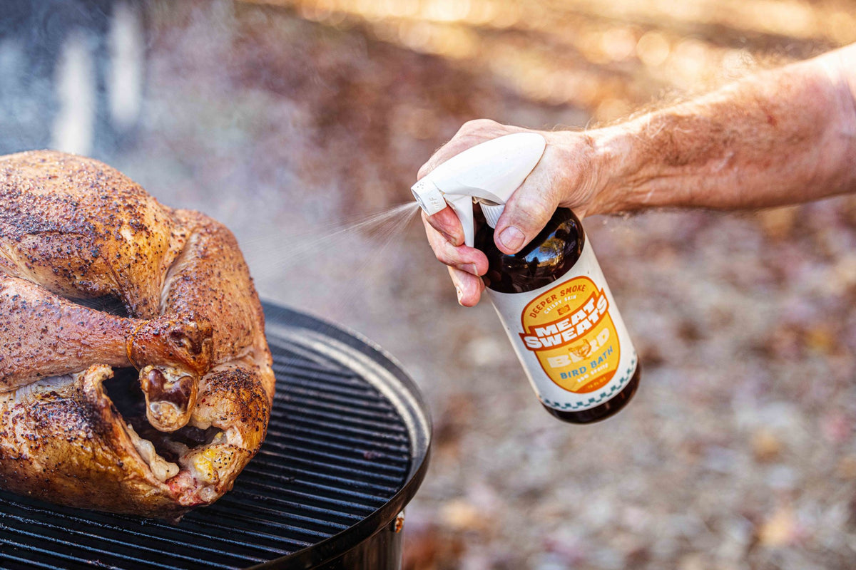 Meat Sweats Bird Bath BBQ spritz being sprayed beside a smoked turkey
