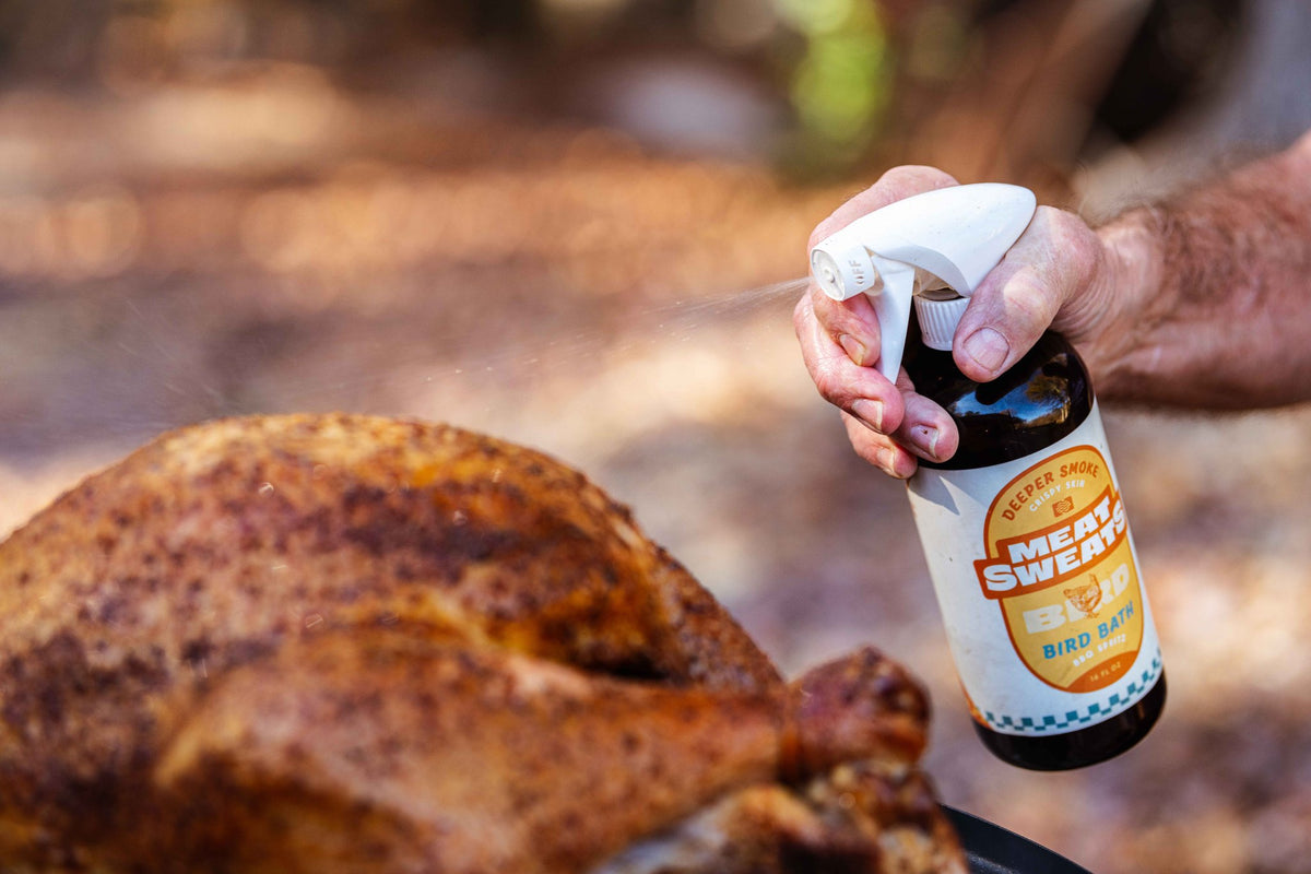 Meat Sweats Bird Bath BBQ spritz bottle beside a smoked turkey