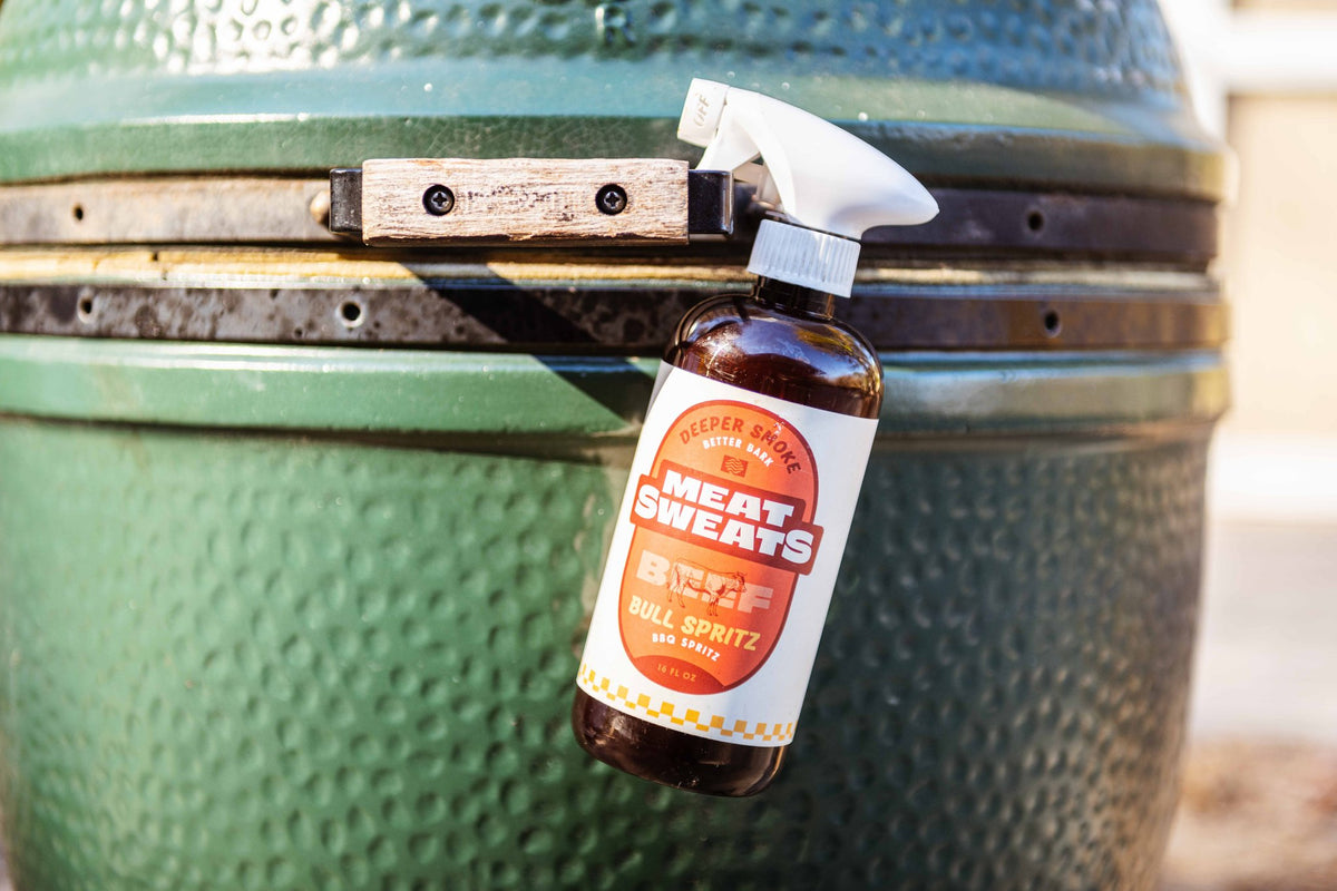Meat Sweats Bull Spritz BBQ spritz bottle beside a ceramic smoker